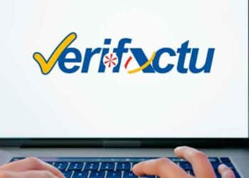 Logo de Verifactu en un portátil con manos tecleando: software de facturación que exigirá Hacienda desde 2025