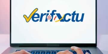 Logo de Verifactu en un portátil con manos tecleando: software de facturación que exigirá Hacienda desde 2025