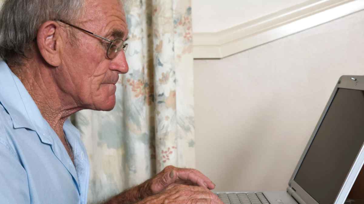 Anciano comprobando ordenador.
