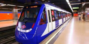 Niños madrileños enseñan su tarjeta roja Abono 7-14 en el andén del Metro, símbolo del transporte gratis 2025.