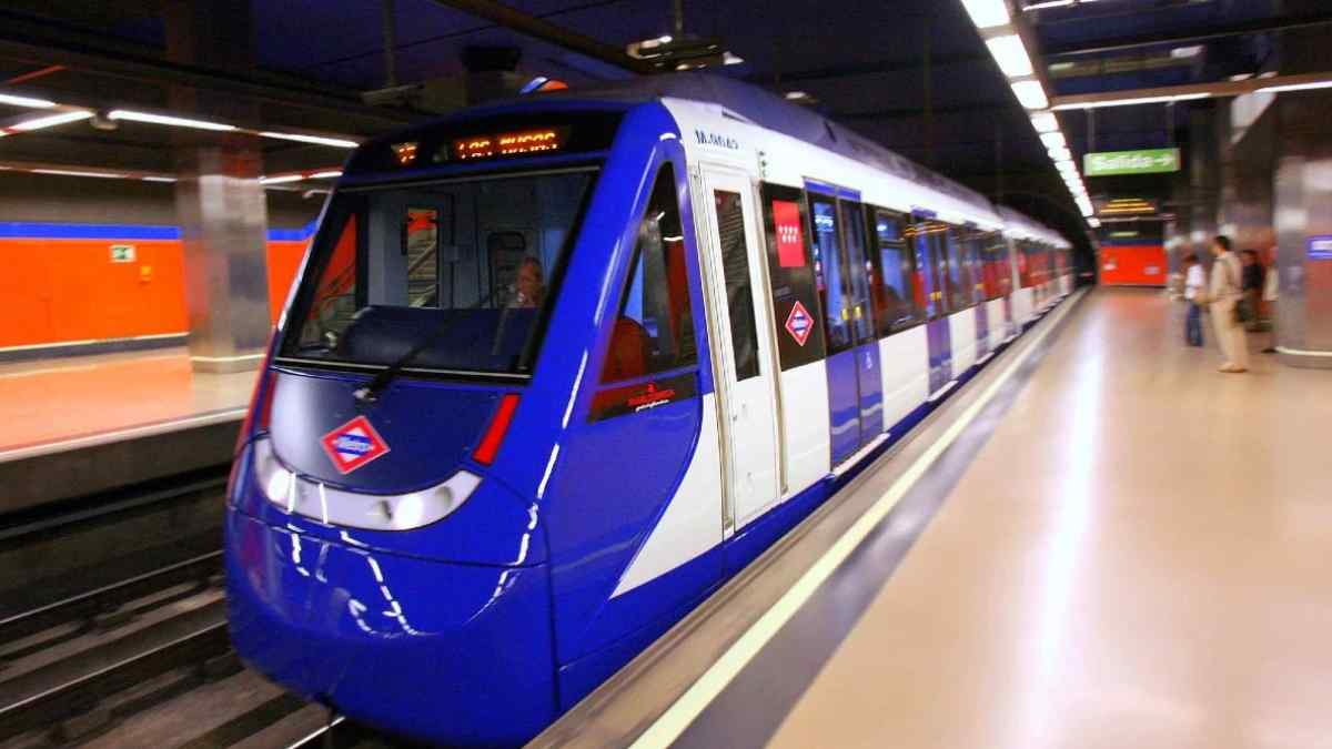 Niños madrileños enseñan su tarjeta roja Abono 7-14 en el andén del Metro, símbolo del transporte gratis 2025.