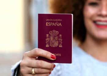 Mujer mostrando un pasaporte español; plazo Ley de Nietos hasta 22 octubre 2025