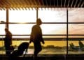 Desempleado con maleta en un aeropuerto al amanecer; viajar sin avisar al SEPE puede hacer perder la prestación por desempleo
