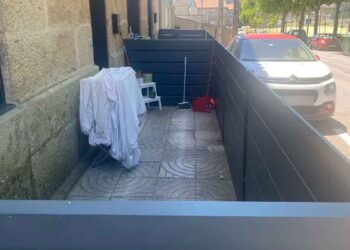 Acera pública en Navia (Vigo) cerrada con paneles para usarla como terraza particular; el Ayuntamiento exige derribarla