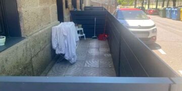Acera pública en Navia (Vigo) cerrada con paneles para usarla como terraza particular; el Ayuntamiento exige derribarla
