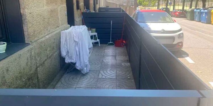 Acera pública en Navia (Vigo) cerrada con paneles para usarla como terraza particular; el Ayuntamiento exige derribarla