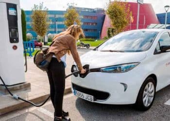 Mujer cargando coche eléctrico en Madrid gracias a las ayudas Cambia 360 de hasta 8.500 euros.