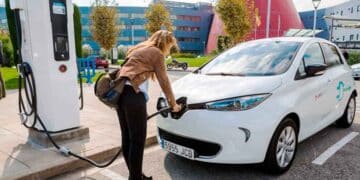 Mujer cargando coche eléctrico en Madrid gracias a las ayudas Cambia 360 de hasta 8.500 euros.