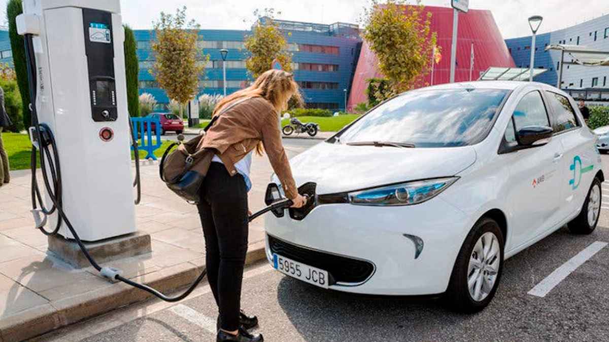 Mujer cargando coche eléctrico en Madrid gracias a las ayudas Cambia 360 de hasta 8.500 euros.