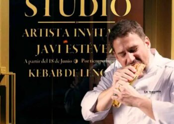 Chef Javi Estévez comiendo un kebab de lengua frente al escaparate de La Tasquería en Madrid
