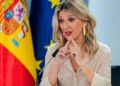 La ministra de Trabajo gesticula en rueda de prensa sobre el salario mínimo interprofesional, con banderas de España y la Unión Europea al fondo