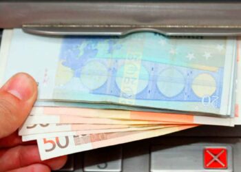 Mano retirando billetes de 20 y 50 € en cajero, símbolo del cobro del paro de junio 2025 adelantado por varios bancos