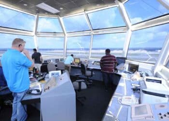 controladores aéreos en torre de control de aeropuerto español supervisan vuelos requisitos exámenes curso.