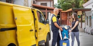 Repartidor de Correos entrega equipaje con el servicio Envío de Maletas del plan verano 2025.