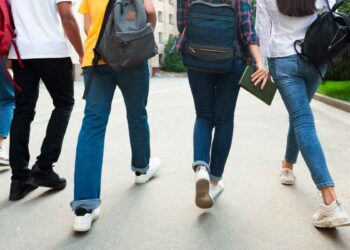 Grupo de estudiantes de Formación Profesional de Madrid caminando con mochilas hacia su centro educativo