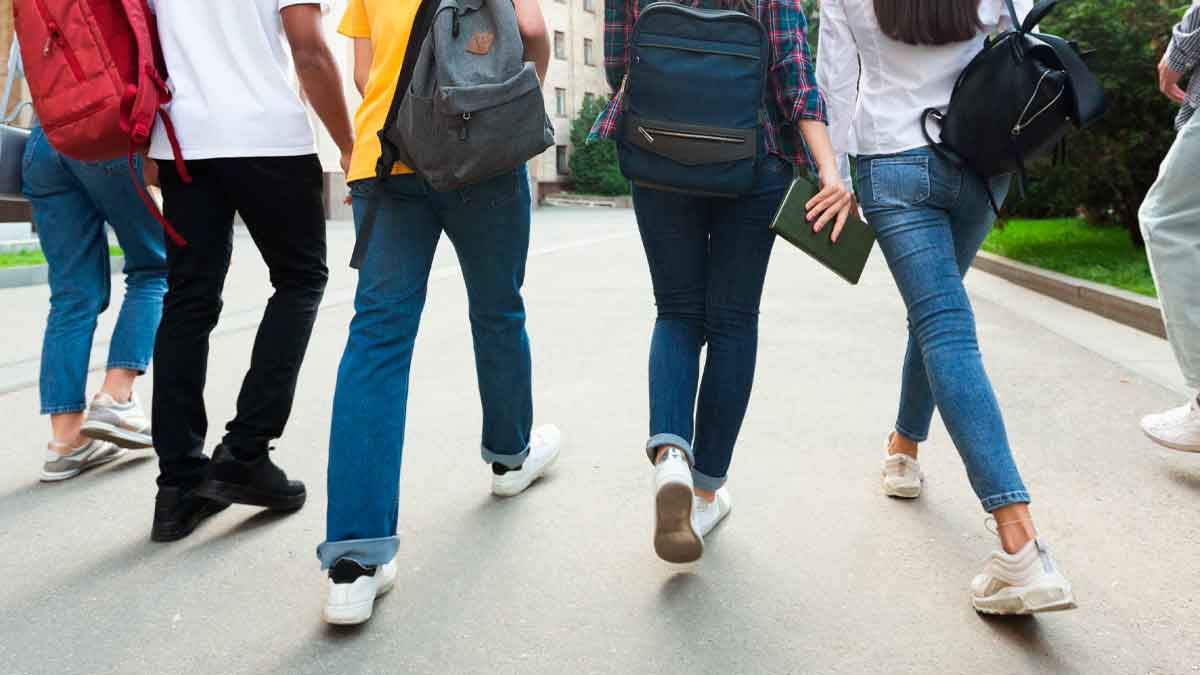Grupo de estudiantes de Formación Profesional de Madrid caminando con mochilas hacia su centro educativo