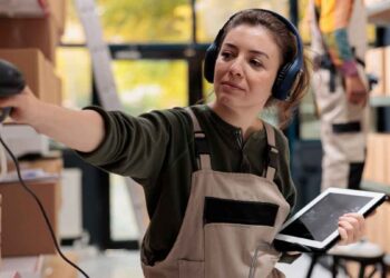Joven alumna escaneando pedidos con lector de radiofrecuencia durante curso gratuito de logística en Madrid