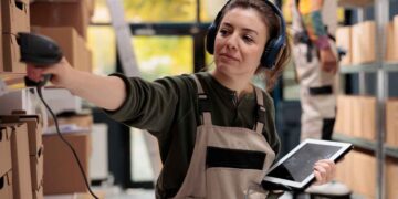 Joven alumna escaneando pedidos con lector de radiofrecuencia durante curso gratuito de logística en Madrid
