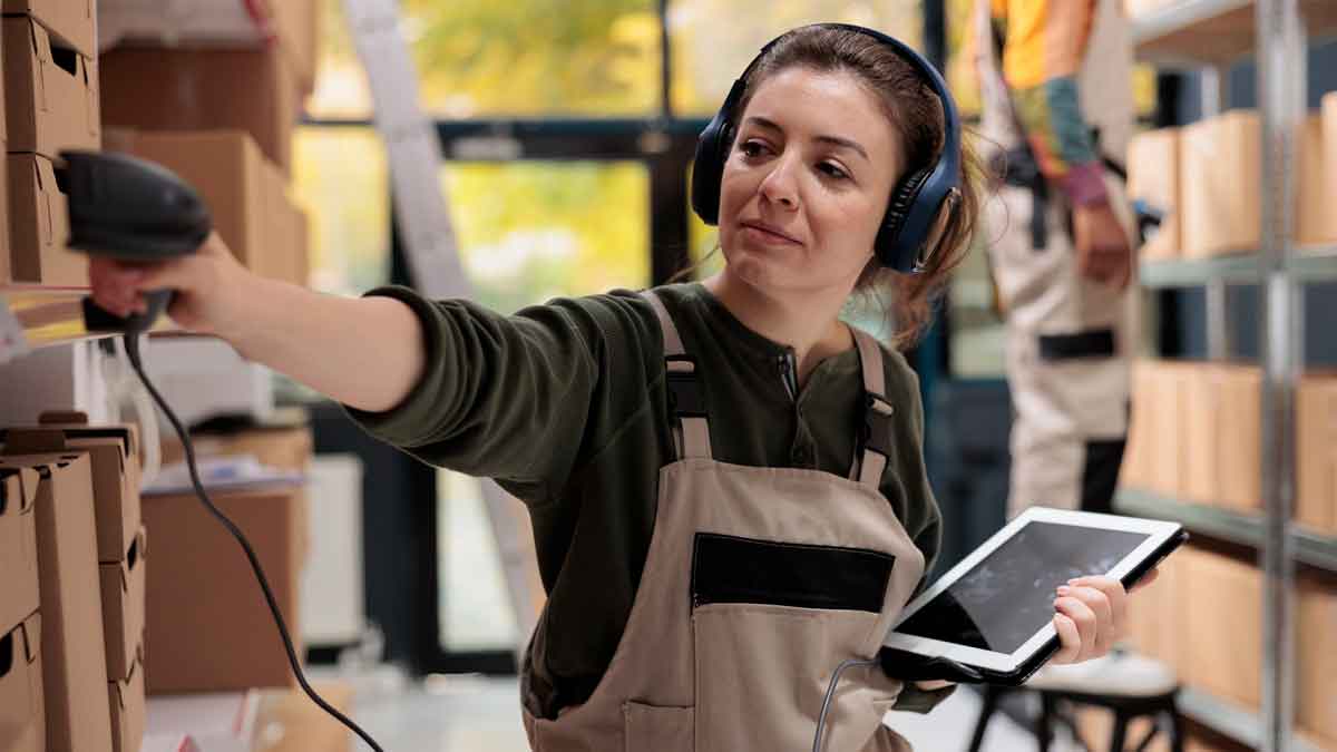 Joven alumna escaneando pedidos con lector de radiofrecuencia durante curso gratuito de logística en Madrid
