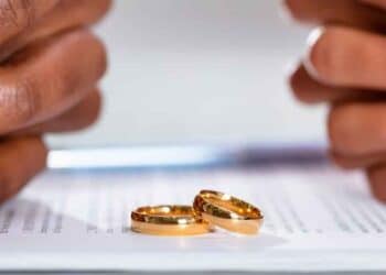 Dos anillos de boda sobre documento de divorcio de pareja extranjera en España
