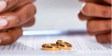 Dos anillos de boda sobre documento de divorcio de pareja extranjera en España