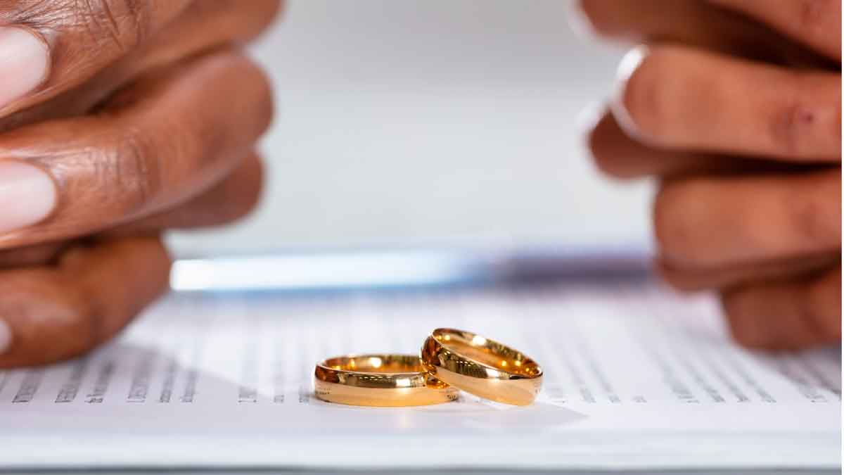 Dos anillos de boda sobre documento de divorcio de pareja extranjera en España