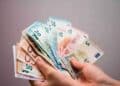 Manos sujetando varios billetes de euro, representación del control de efectivo que vigila Hacienda con posibles multas de hasta 150.000 €