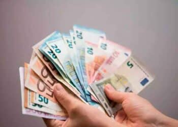 Manos sujetando varios billetes de euro, representación del control de efectivo que vigila Hacienda con posibles multas de hasta 150.000 €
