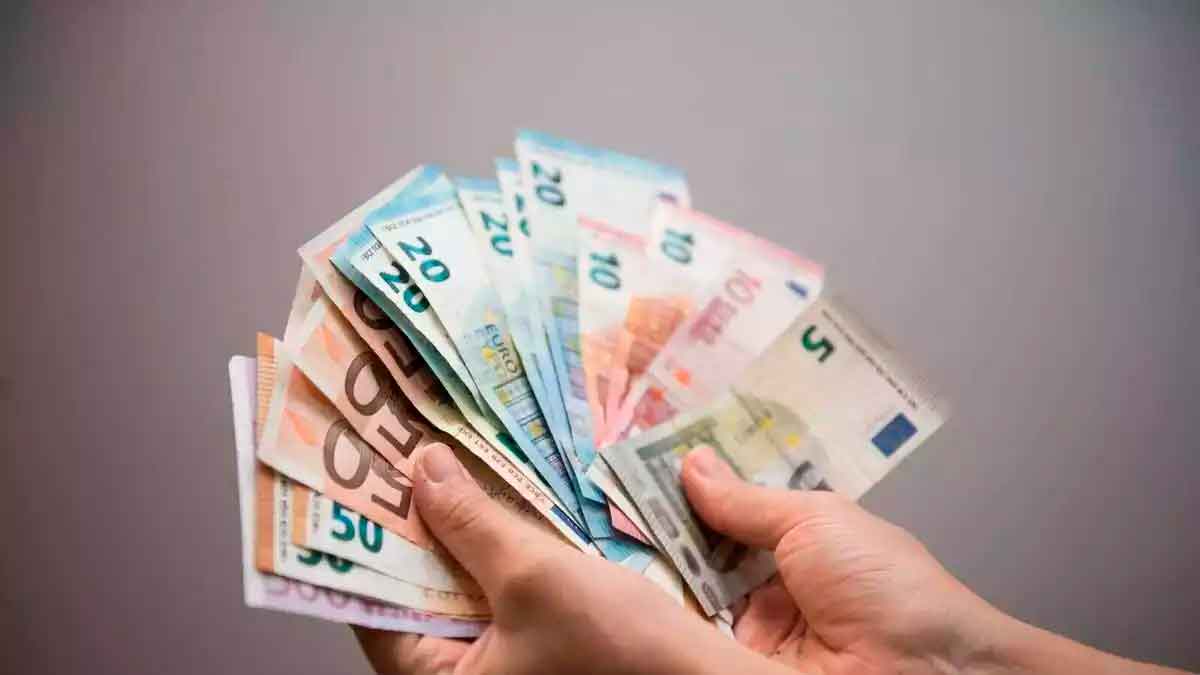 Manos sujetando varios billetes de euro, representación del control de efectivo que vigila Hacienda con posibles multas de hasta 150.000 €