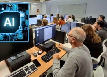 Trabajadores adultos en aula de informática recibiendo formación continua en inteligencia artificial para actualizarse laboralmente.