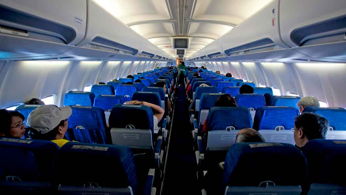 Pasajeros sentados en la cabina de un avión; la aerolínea fue condenada a pagar 3.811 € por retrasos Madrid-Orlando