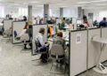 Personas siendo atendidas en cubículos numerados de la Agencia Tributaria para presentar la declaración presencial de la Renta 2024/25