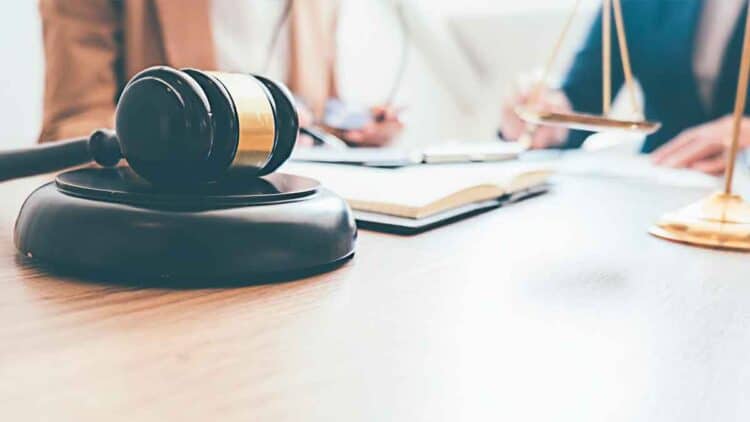Mazo de juez y balanza sobre una mesa, símbolo de la sentencia que garantiza los cinco días de permiso retribuido por cuidados hospitalarios