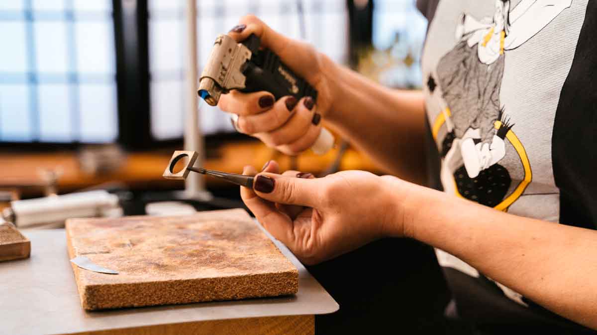 Artesana madrileña soldando una pieza de joyería en su taller, posible beneficiaria de las ayudas de hasta 3.000 €