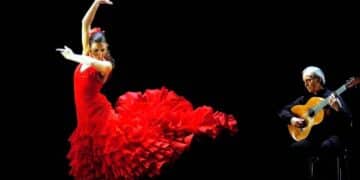 Bailaora flamenca con vestido rojo y guitarrista en escena, símbolo del decreto de Madrid que lleva el flamenco a los estudios superiores