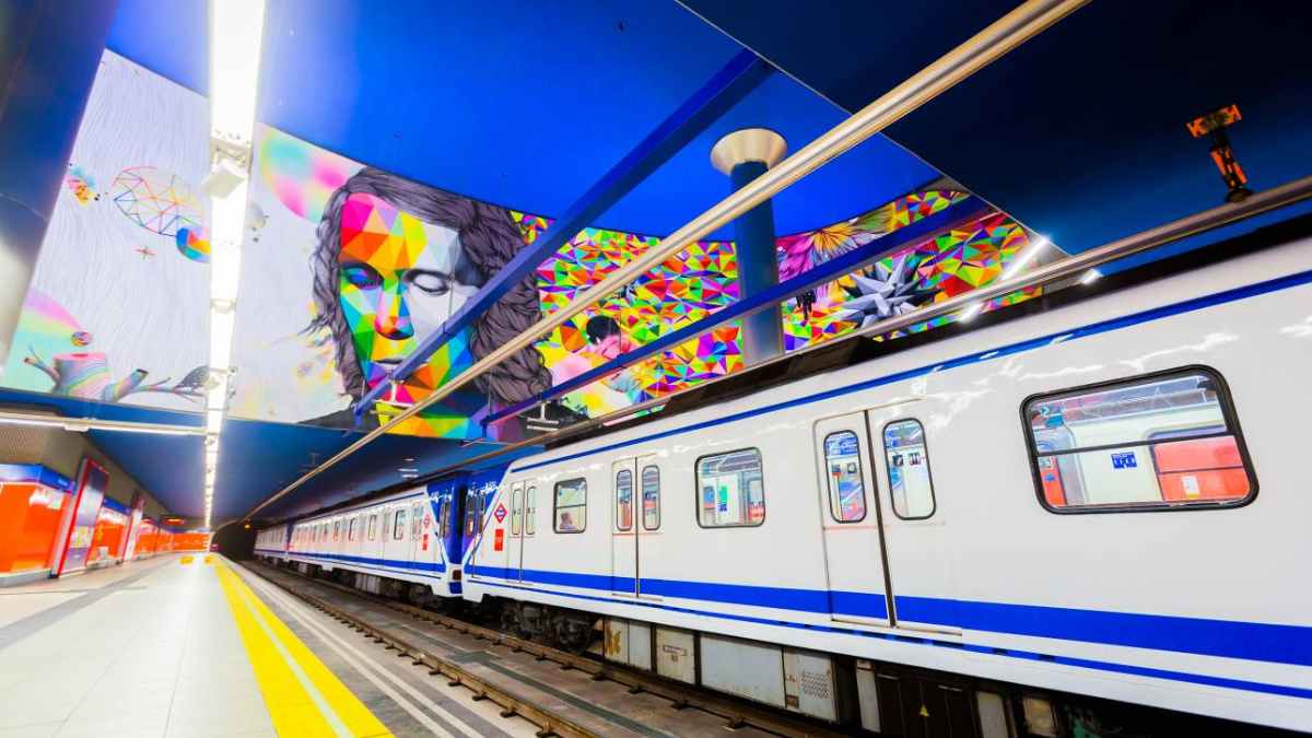 Tren del Metro de Madrid en la estación Paco de Lucía, bajo un mural colorido, ejemplo de la modernización de 2025.