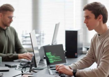 Profesionales jóvenes programando IA y ciberseguridad en una oficina, ejemplo de formación especializada demandada en 2025