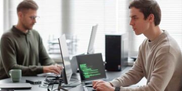 Profesionales jóvenes programando IA y ciberseguridad en una oficina, ejemplo de formación especializada demandada en 2025