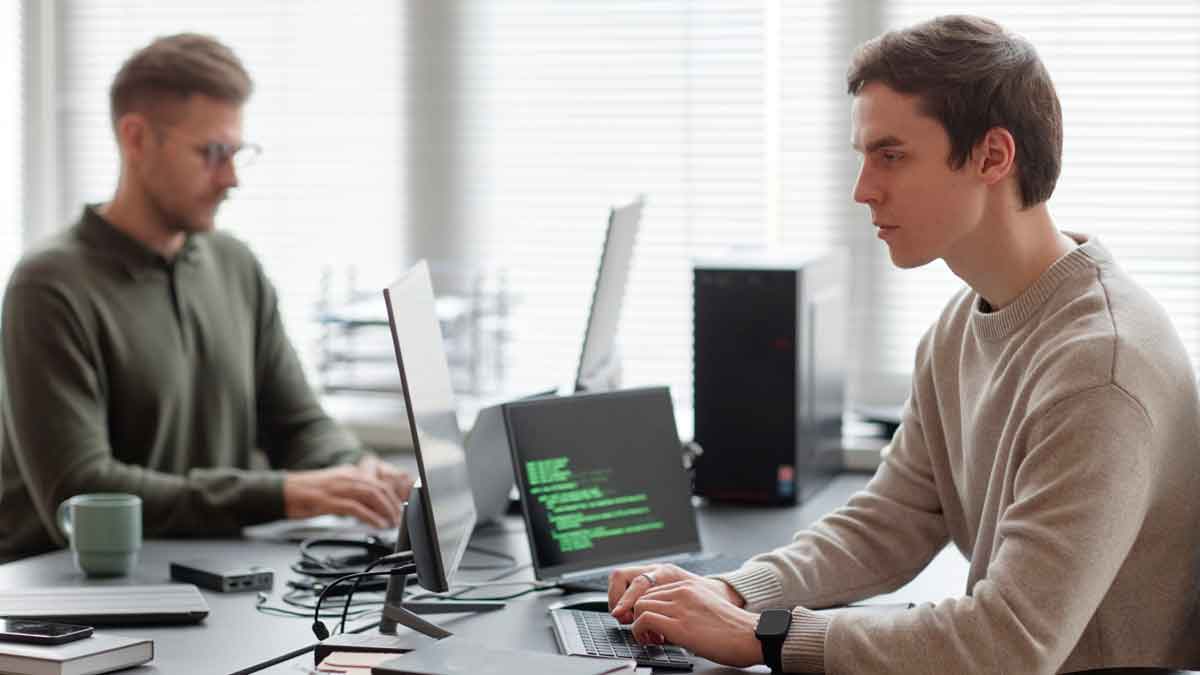 Profesionales jóvenes programando IA y ciberseguridad en una oficina, ejemplo de formación especializada demandada en 2025