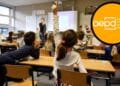 Clase con alumnos y logo de la AEPD; multa de 10 000 € a colegio madrileño por correo a menor sin permiso.