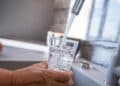 Vaso llenándose con agua del grifo en cocina – OCU revela la ciudad española con la mejor calidad
