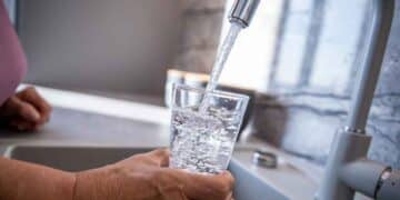 Vaso llenándose con agua del grifo en cocina – OCU revela la ciudad española con la mejor calidad