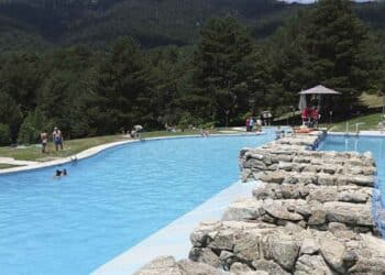 Piscina récord de España en Riosequillo, Buitrago de Lozoya, rodeada de pinos y montañas.