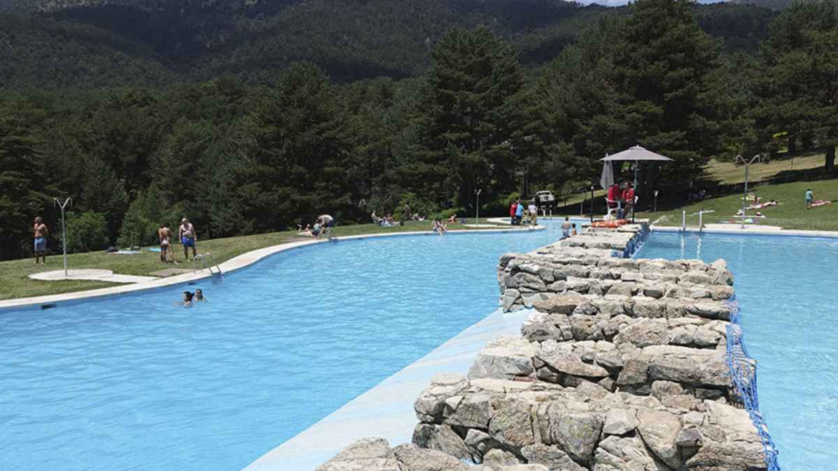 Piscina récord de España en Riosequillo, Buitrago de Lozoya, rodeada de pinos y montañas.