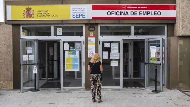 Mujer ante la Oficina de Empleo de Madrid, foco del debate sobre retirar la prestación por desempleo.