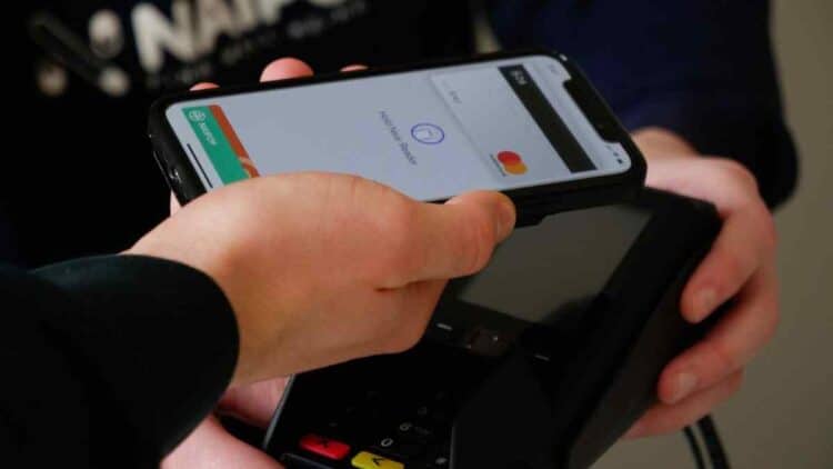 Cliente paga con móvil en datáfono que sugiere propina en bar de Madrid.