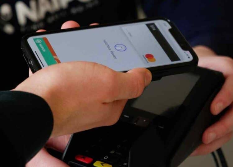 Cliente paga con móvil en datáfono que sugiere propina en bar de Madrid.