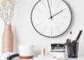 Reloj de pared y taza de café en escritorio que simbolizan los 15 minutos de cortesía y el descanso laboral avalados por el Supremo