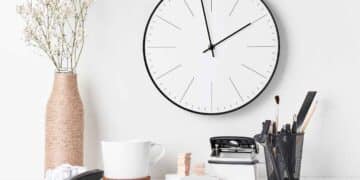 Reloj de pared y taza de café en escritorio que simbolizan los 15 minutos de cortesía y el descanso laboral avalados por el Supremo