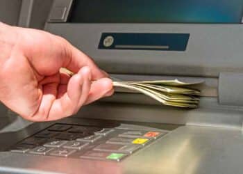 Mano retirando efectivo de un cajero automático; la nueva ley de accesibilidad exige interfaces inclusivas desde el 28 de junio en España.